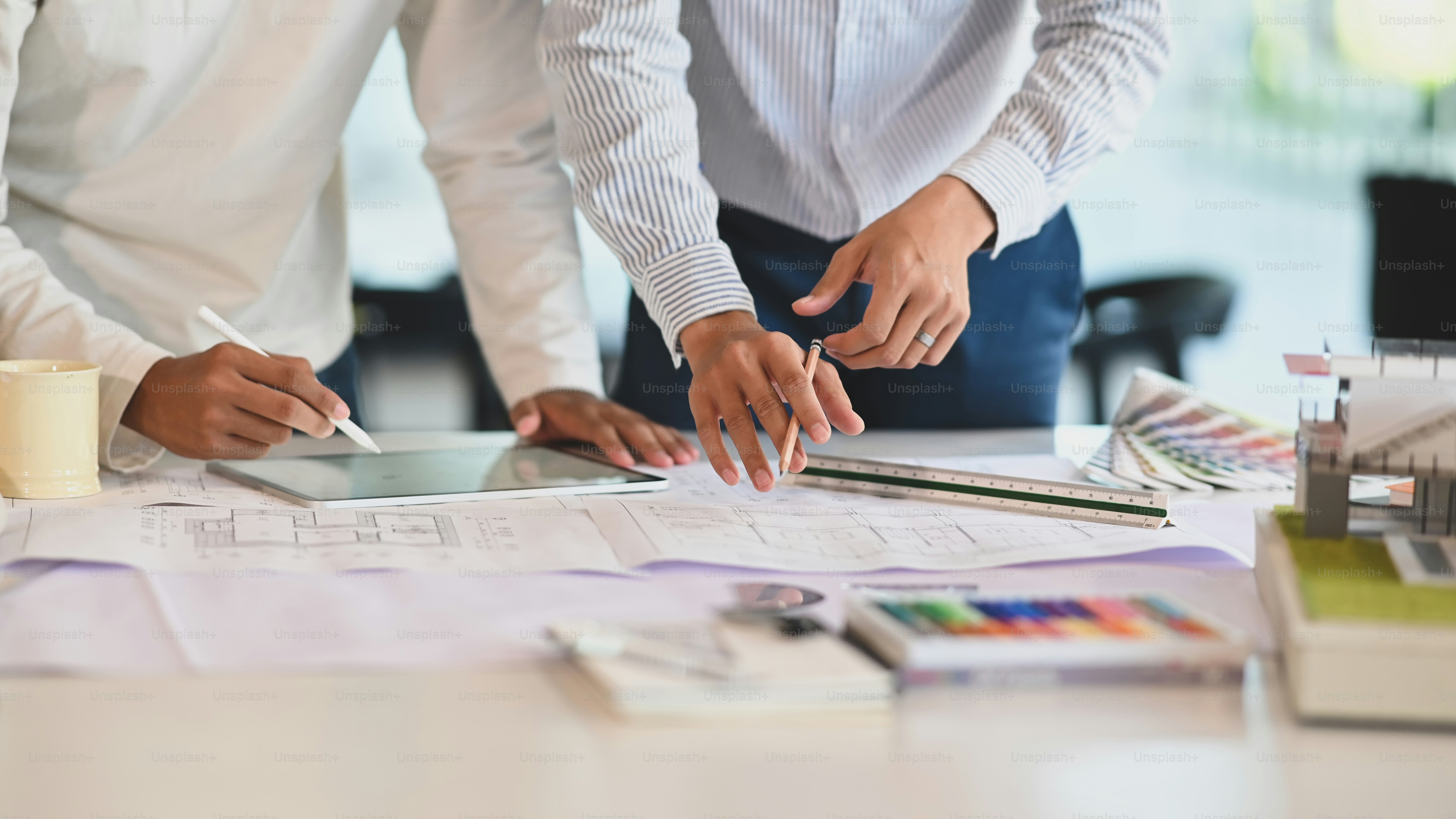 Architecture brainstorming with tablet and blueprints.