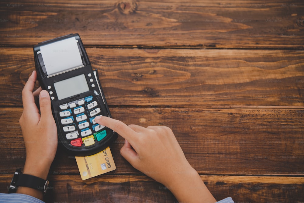 Vista dall'alto Pagare con carta di credito, acquistare e vendere prodotti utilizzando una macchina a strisciare per carte di credito