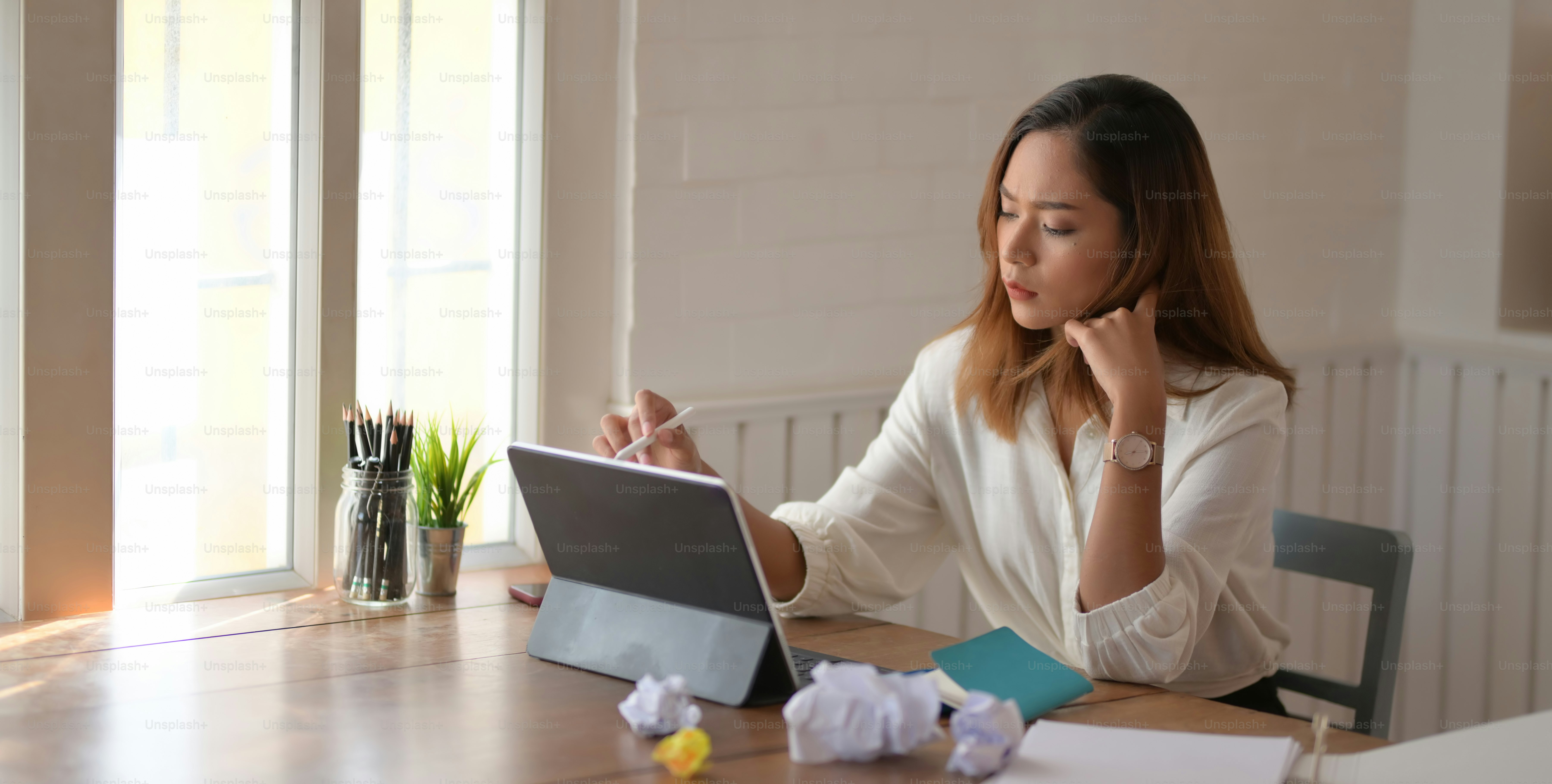 Young professional businesswoman focusing on her project with digital tablet in comfortable office room