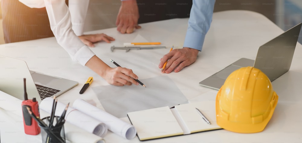 Young professional architect and engineer working on their construction project together