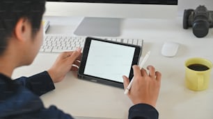 Creative man using mockup digital tablet on workspace.