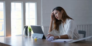 Tired beautiful asian business woman working with headache in modern office room