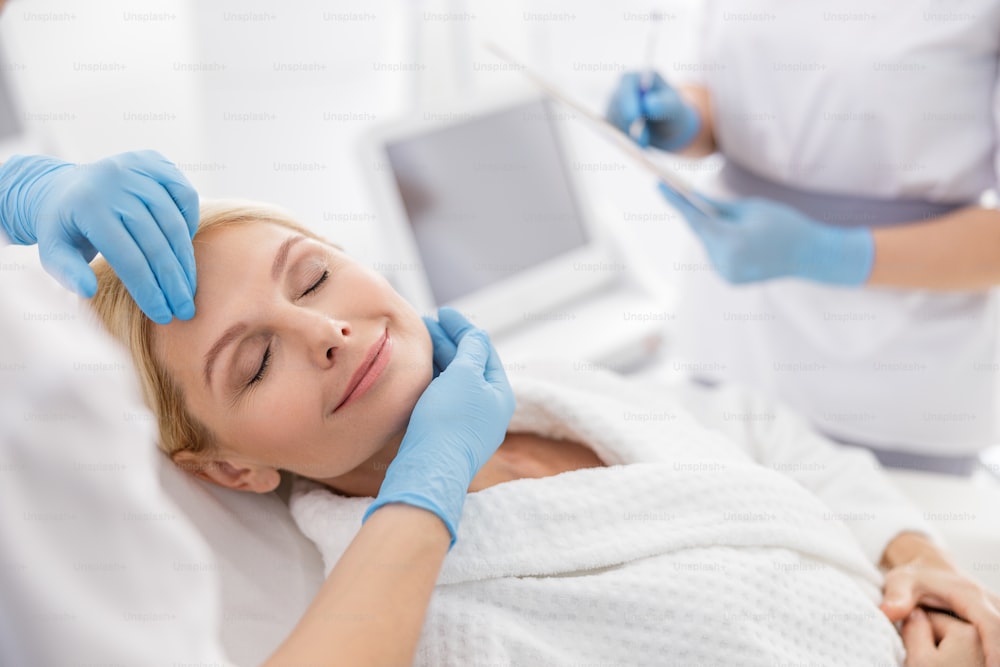 Happy woman before lifting procedure in beauty salon stock photo