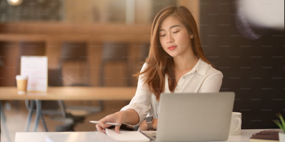 Jeune femme d’affaires prospère travaillant sur son projet dans un bureau moderne