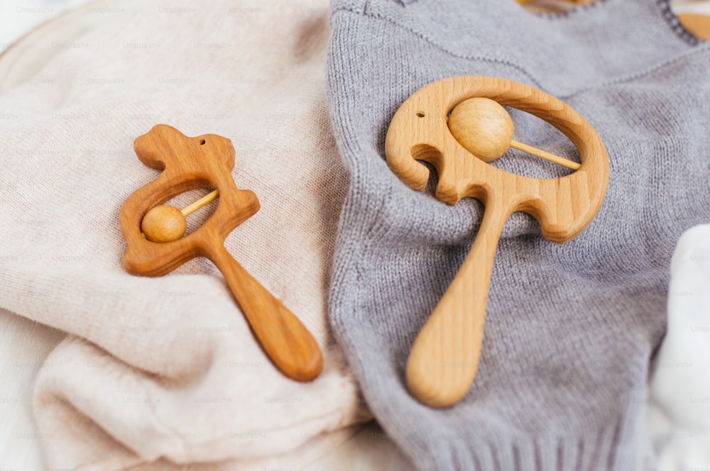 Brinquedos orgânicos de madeira do dente-de-leite do coelho e do elefante no fundo do material tricotado