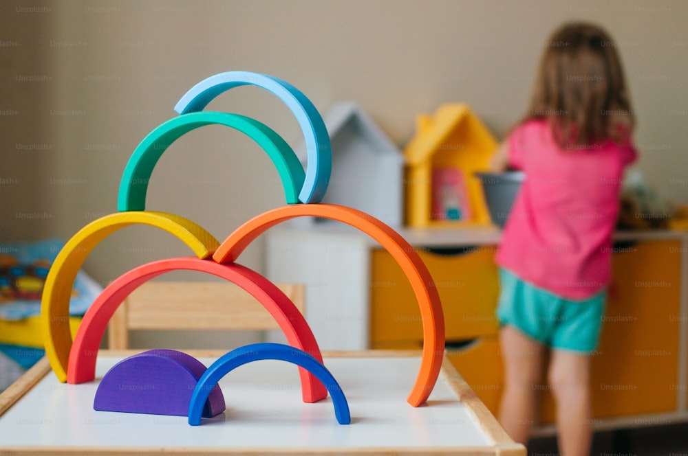 Bunter Holzspielzeugregenbogen auf dem Tisch im Kinderzimmer. Selektiver Fokus auf den Regenbogen.