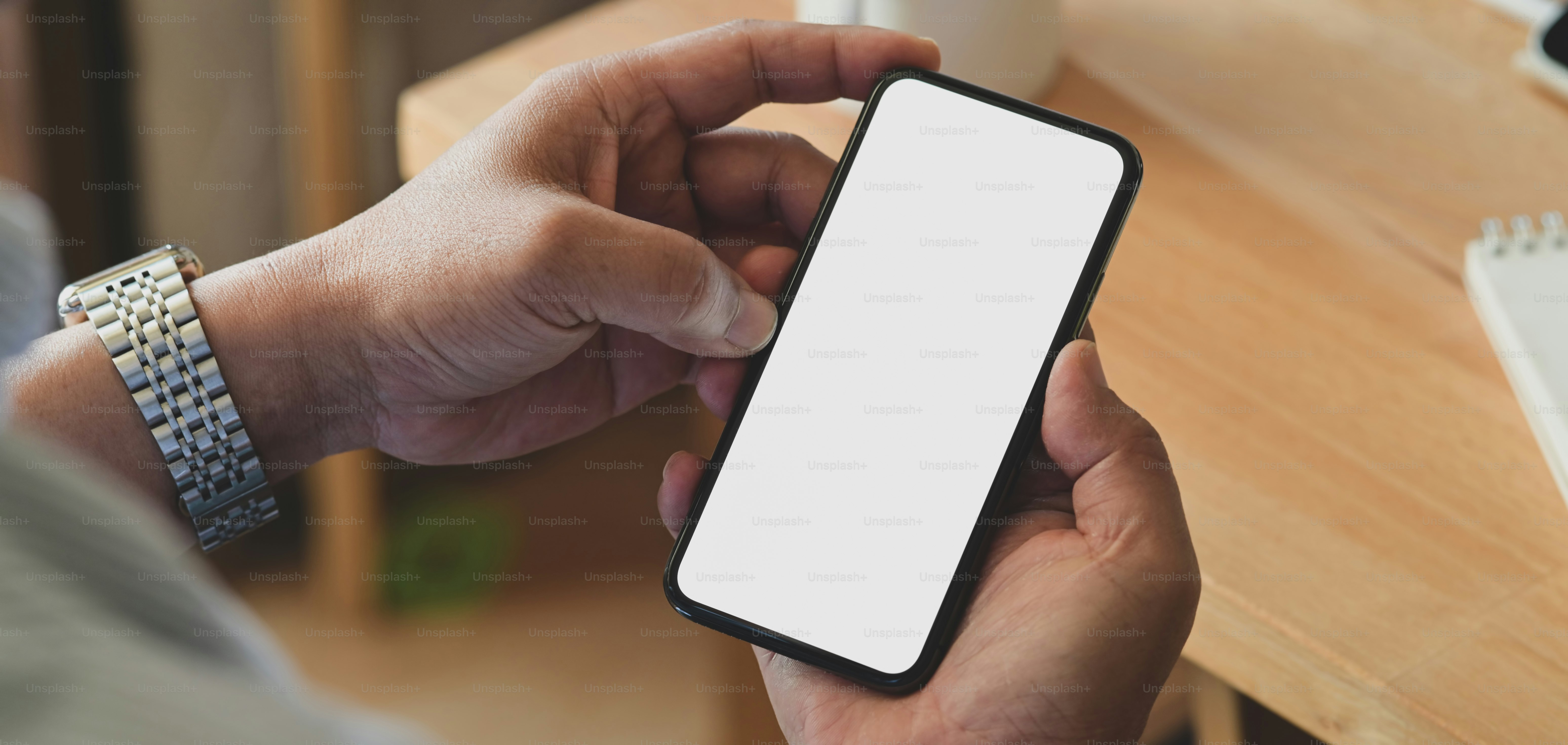 Cropped shot of young man holding blank screen smartphone in ...