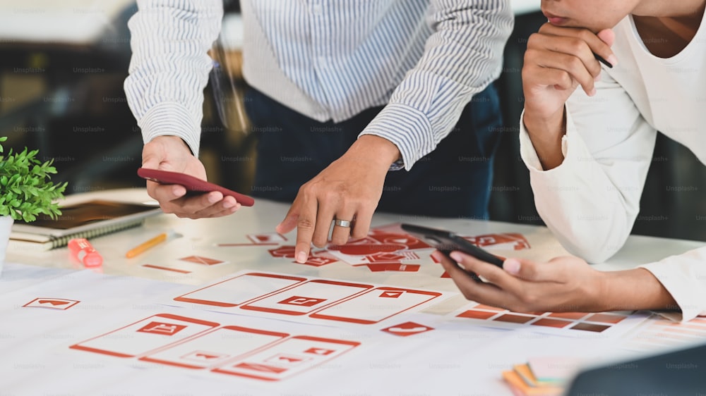 Nahaufnahme des UX UI Designer-Teams treffen / planen auf dem Schreibtisch.