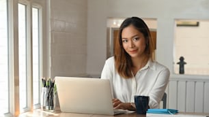 Portrait shot businesswoman sitting on home office.