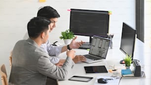 노트북으로 작업하고 컴퓨터에서 코딩하는 두 명의 남성 프로그래머.