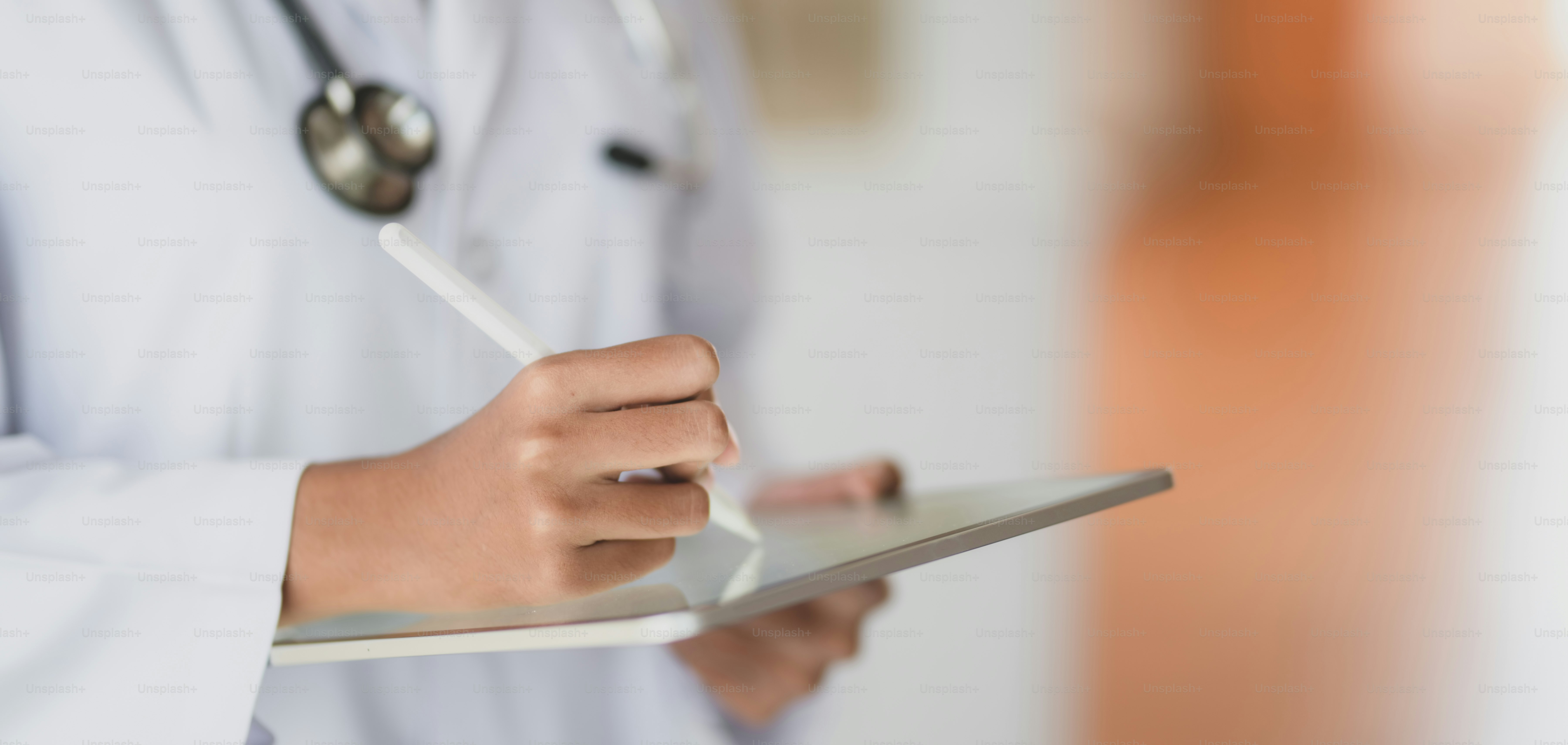 병원 사무실에서 태블릿으로 의료 기록 및 검사 결과를 작업하는 젊은 여성 의사의 자른 샷