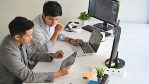 A two male programer working with laptop and coding on computer.