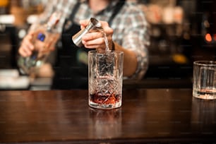 Cropped photo of barman pouring fresh alcoholic drink into the glasses stock photo