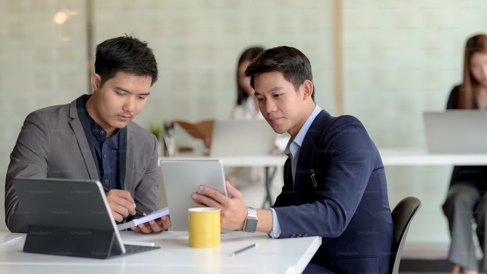 Close up view of two of businessman discussing on their task while sitting in modern co working space room