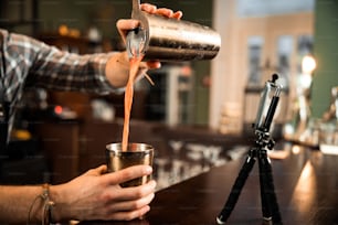 Cropped photo of barman using mobile phone for his vlog while making video