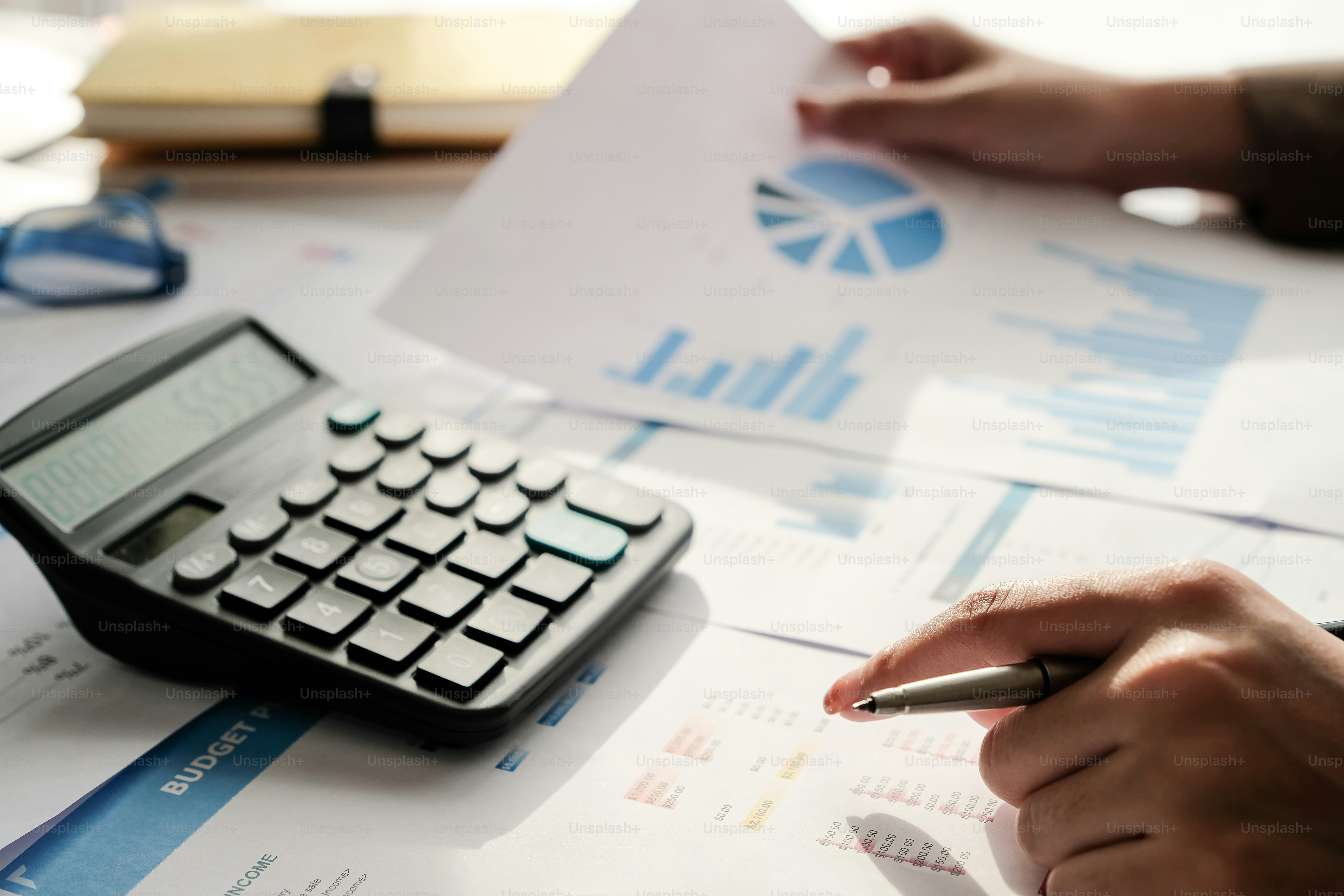 business woman working on desk office with using a calculator to calculate the numbers, finance accounting concept