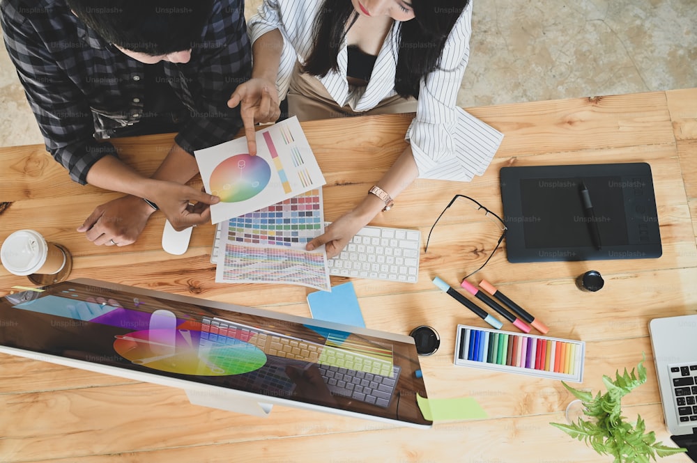 Top View Creative Designer Team diskutiert / brainstorming über Farbe aus Farbpalette / Farbfeldern. Draufsicht auf den Schreibtisch des kreativen Designerteams inklusive Designerausstattung.