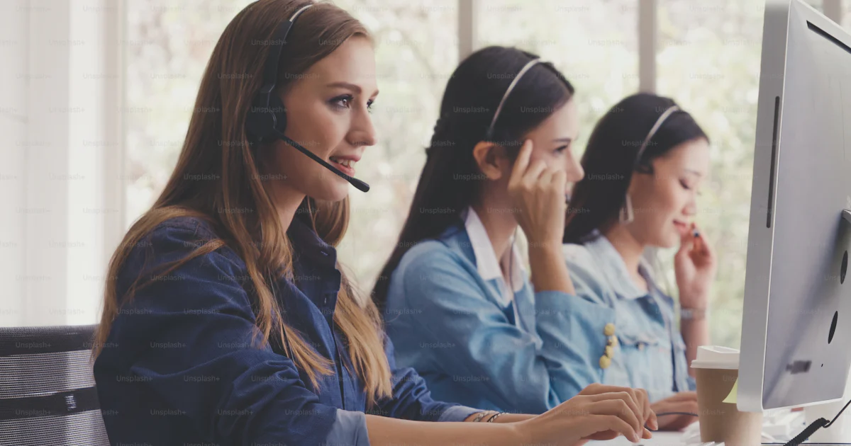 Customer support agent or call center with headset works on desktop ...