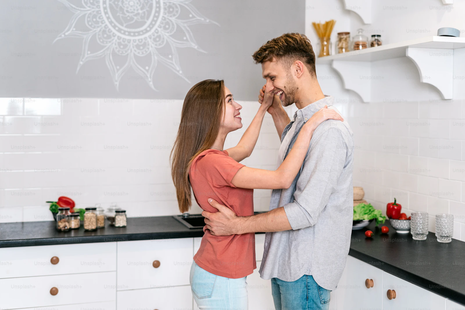 A couple dancing playfully together in their kitchen, smiling