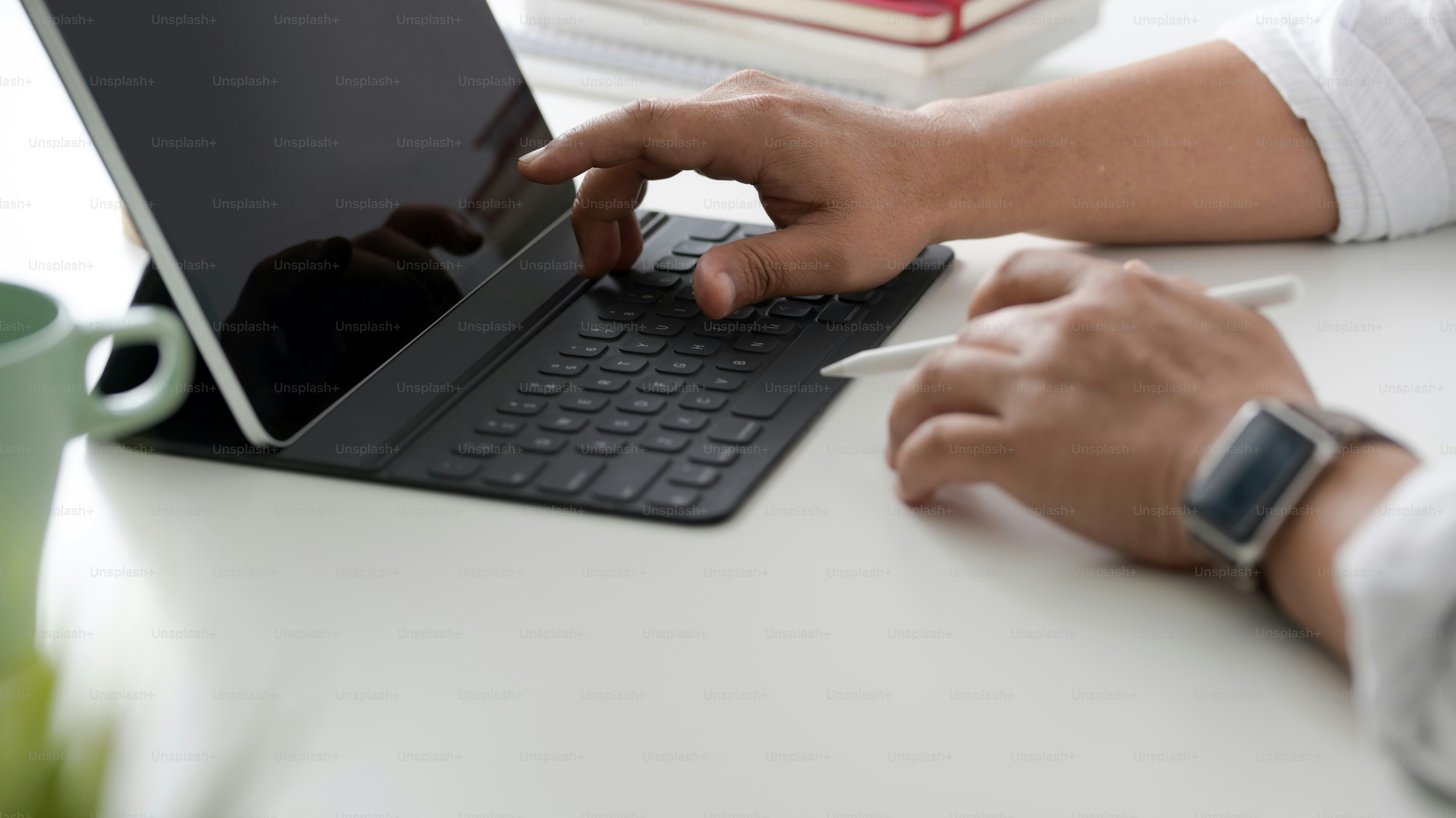 Cropped shot of businessman working on his task while typing on tablet ...