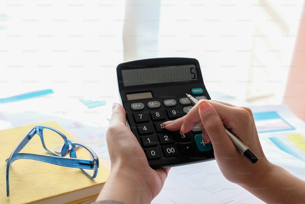 Cerrar Contador usando calculadora para calcular gastos financieros en la oficina en casa
