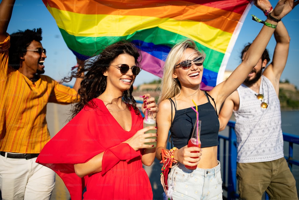 Happy group of friends, people attend a gay pride event