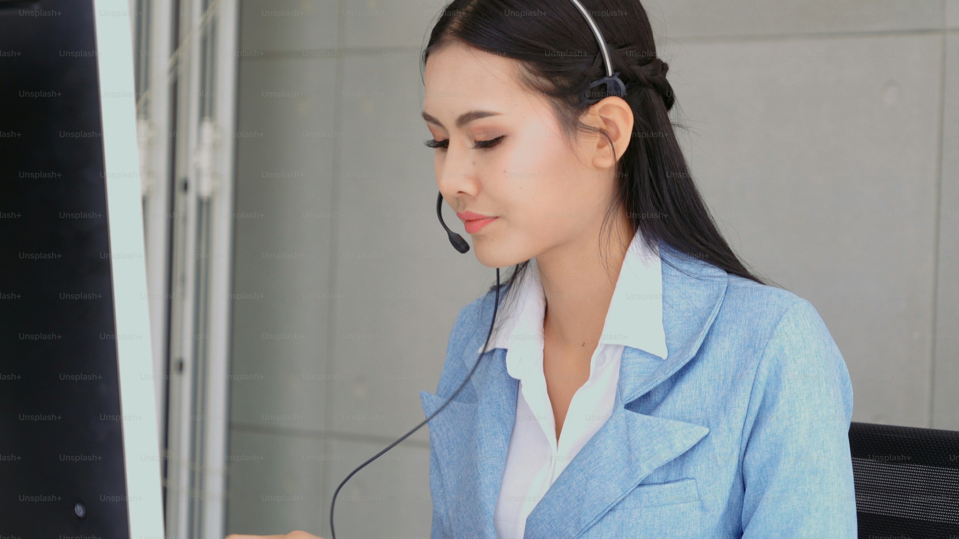 Customer support agent or call center with headset works on desktop ...