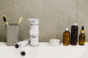 Bambuszahnbürste, ubtan für die Haut, festes Shampoo in Metalldose, Zahnpasta in Metalltube, Tonic auf weißem Waschbecken im modernen Badezimmer. Zero-Waste-Konzept. Plastikfrei. Nachhaltiger Lebensstil