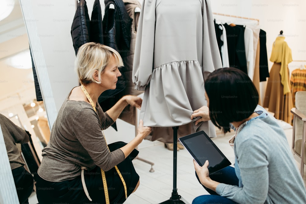 Two professional designers working in fashion studio. Creative people concept.