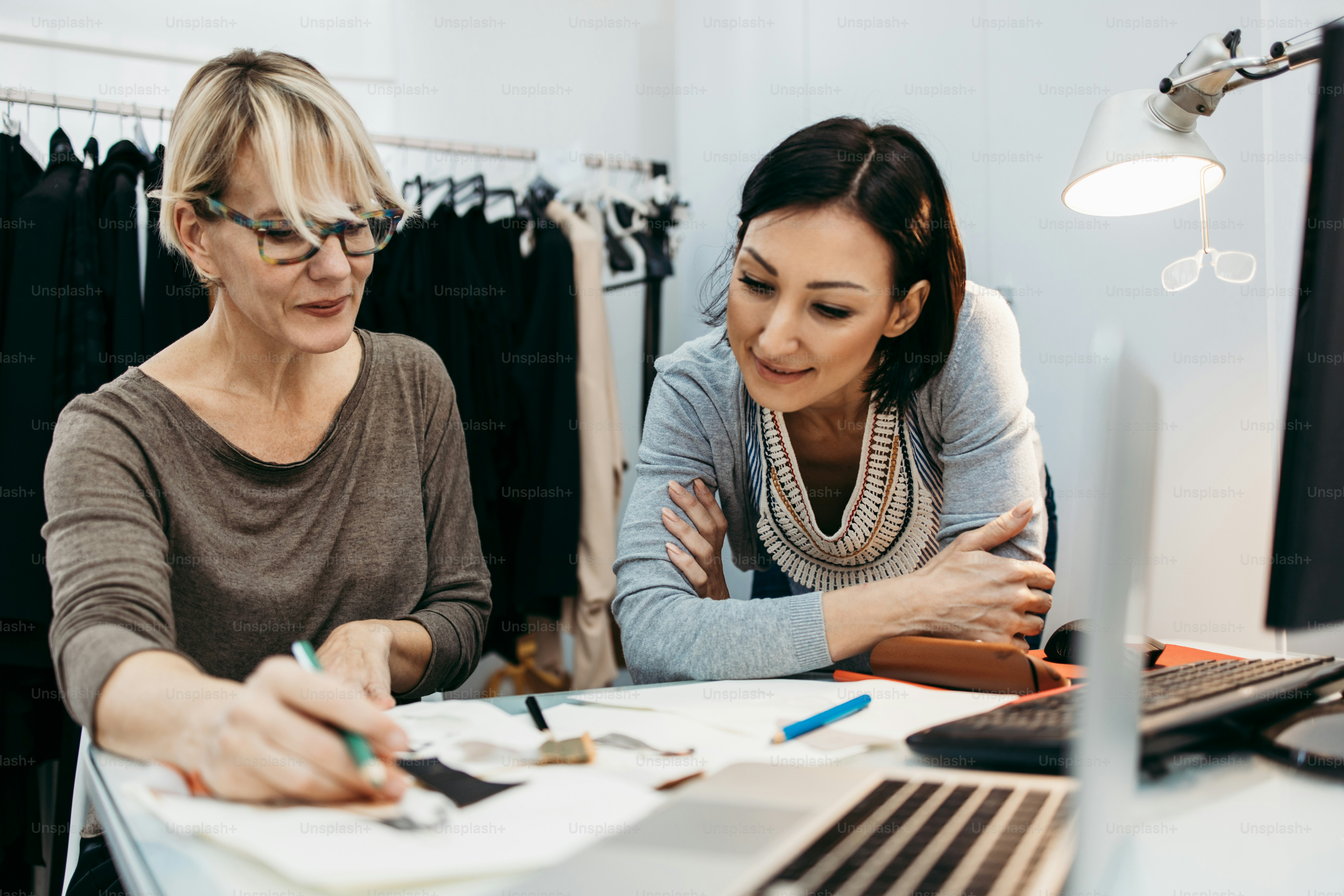 Two professional designers working in fashion studio. Creative people concept.