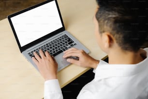 Pessoa de negócios ou trabalhador de escritório usando laptop enquanto está sentado na mesa.
