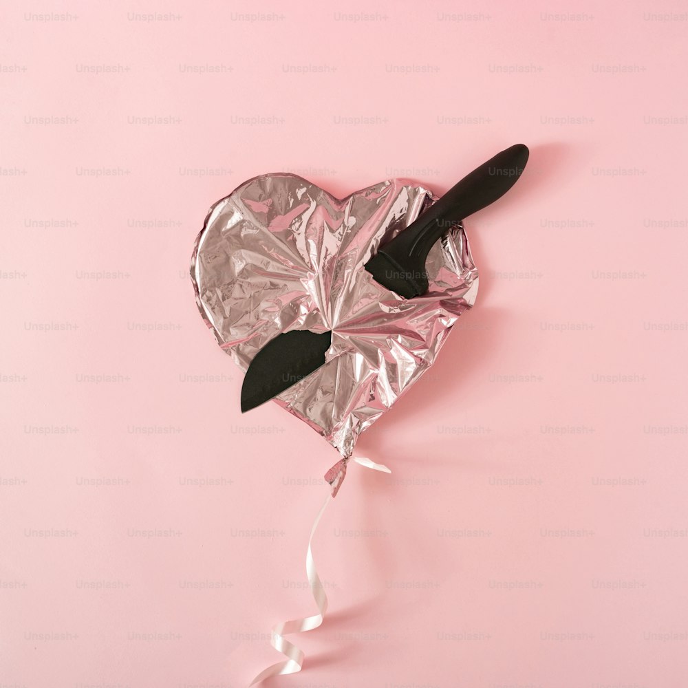 Heart shaped foil balloon with knife. Minimal flat lay.