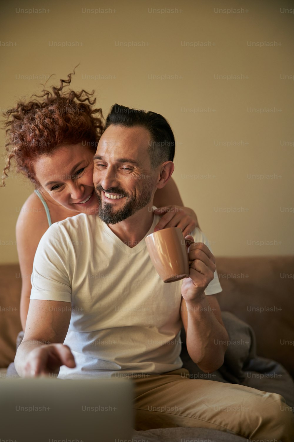 Lovely mature couple embracing and enjoying themselves on their bed at home stock photo