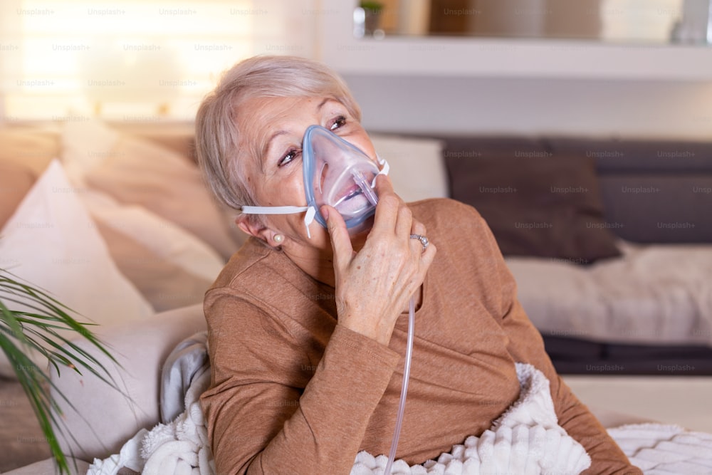 Sick elderly woman making inhalation, medicine is the best medicine. Ill senior woman wearing an oxygen mask and undergoing treatment. Senior woman with an inhaler