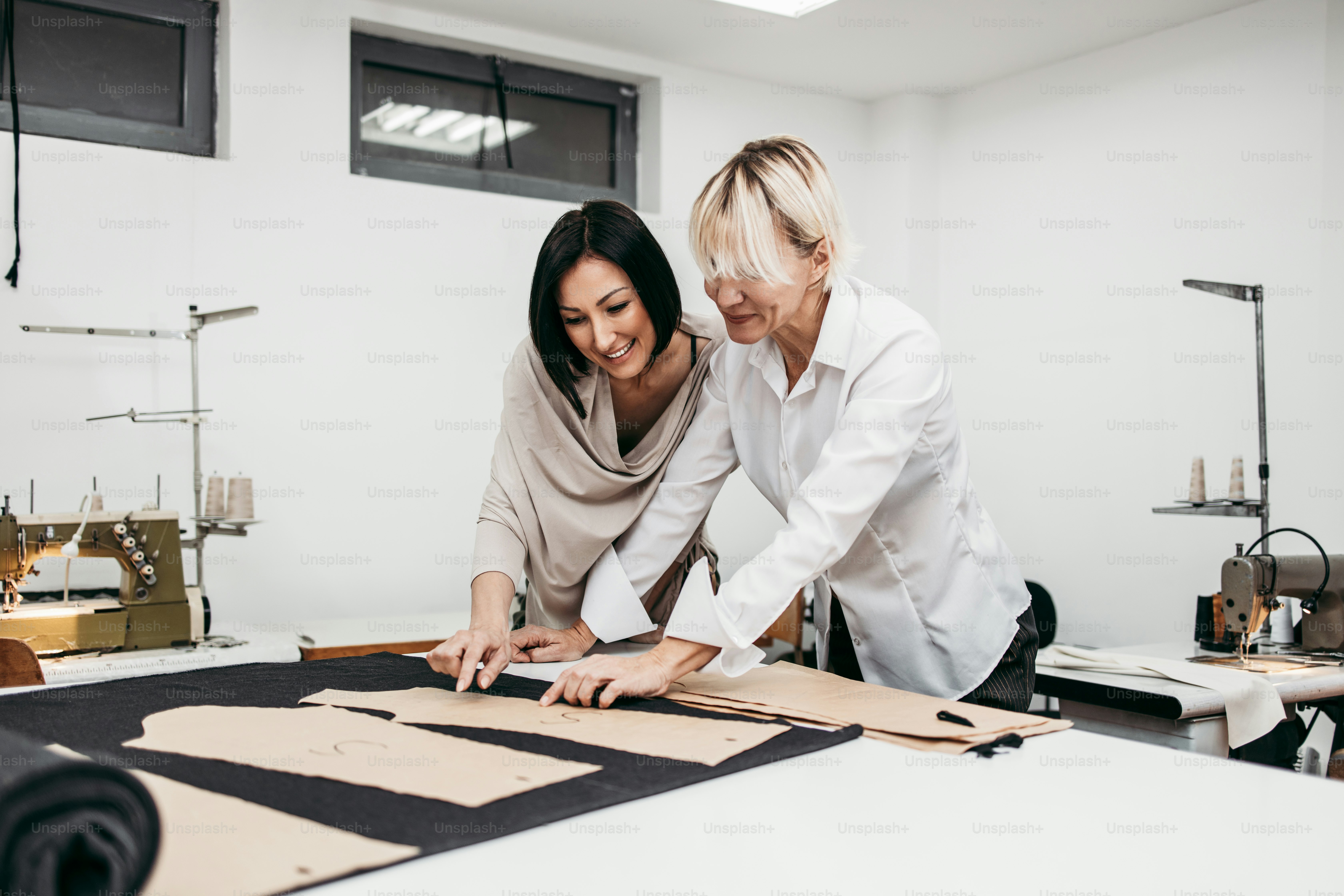 Two professional designers working in fashion studio. Creative people ...