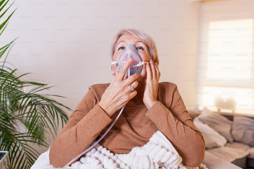 Sick elderly woman making inhalation, medicine is the best medicine. Ill senior woman wearing an oxygen mask and undergoing treatment. Senior woman with an inhaler