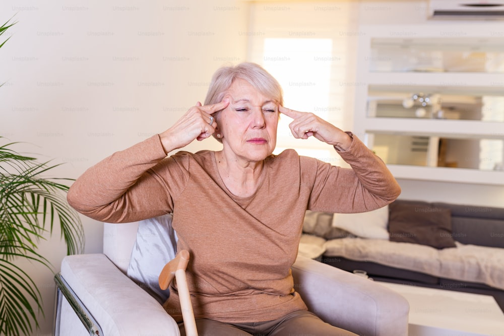스트레스나 두통으로 고통스러워하는 여성. 편두통이 있는 노인 여성은 몸이 좋지 않습니다. 두통을 앓고 있는 매력적인 노인 여성의 초상화, 고통을 느낀다