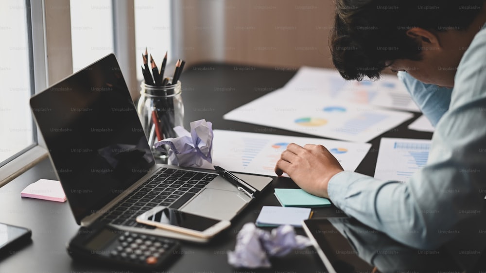 Photo of young businessman hand on his head at the working desk after feeling frustrated exhausted from work. Frustrated/Stress from work.