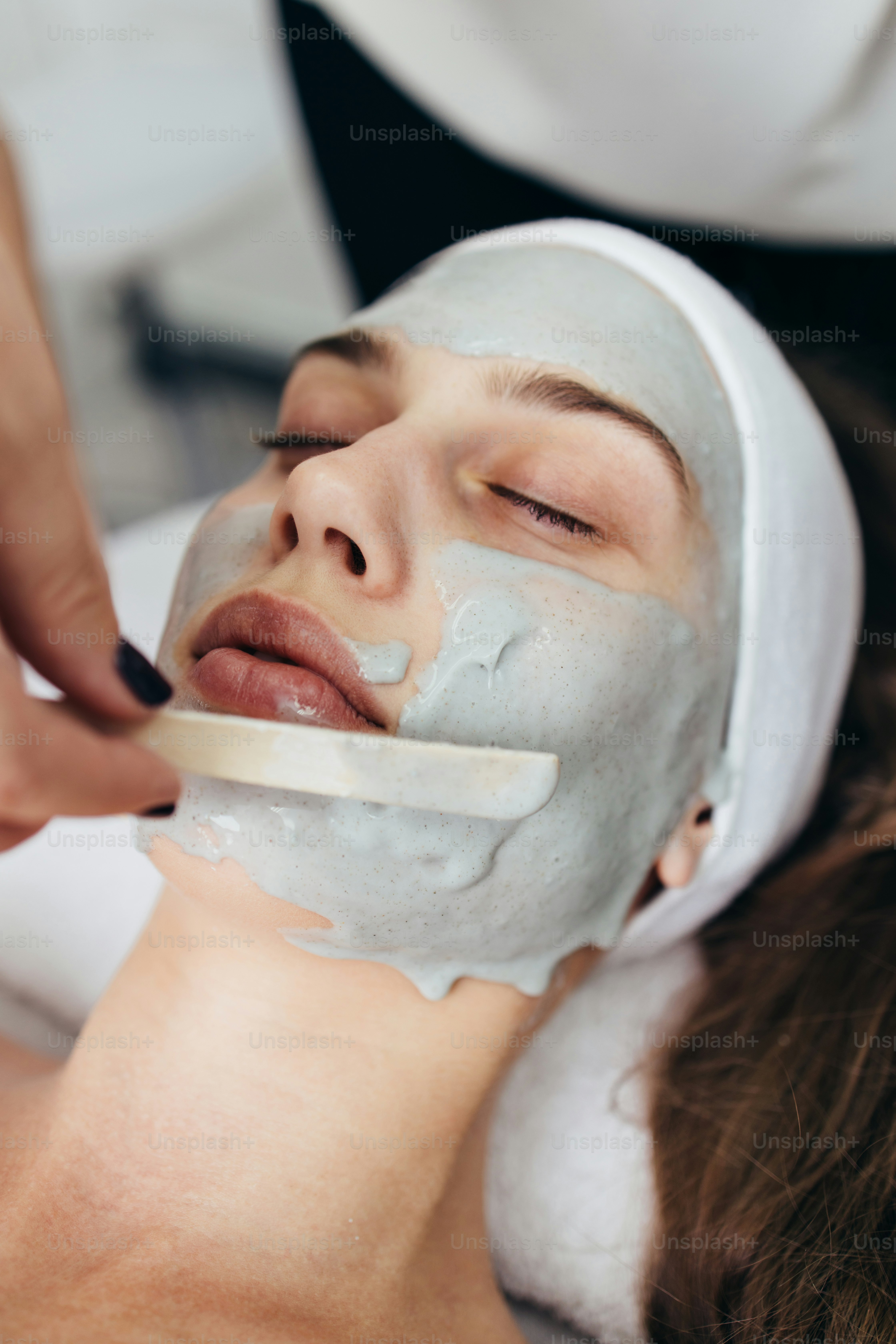 Beautiful and attractive adult woman receiving professional face skin beauty treatment