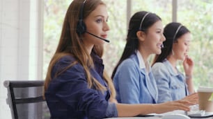 Customer support agent or call center with headset works on desktop computer while supporting the customer on phone call. Operator service business representative concept.