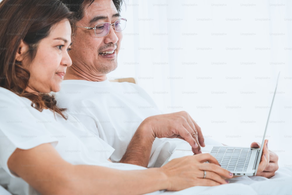 Happy Asian senior couple having good time at home. Old people retirement and healthy citizens elderly concept.