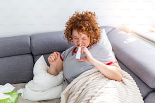 Woman is having allergies and she is using nasal spray to help herself. Woman using nasal spray. Nasal spray to help a cold. Sick with a rhinitis woman dripping nose. Woman applies nasal spray