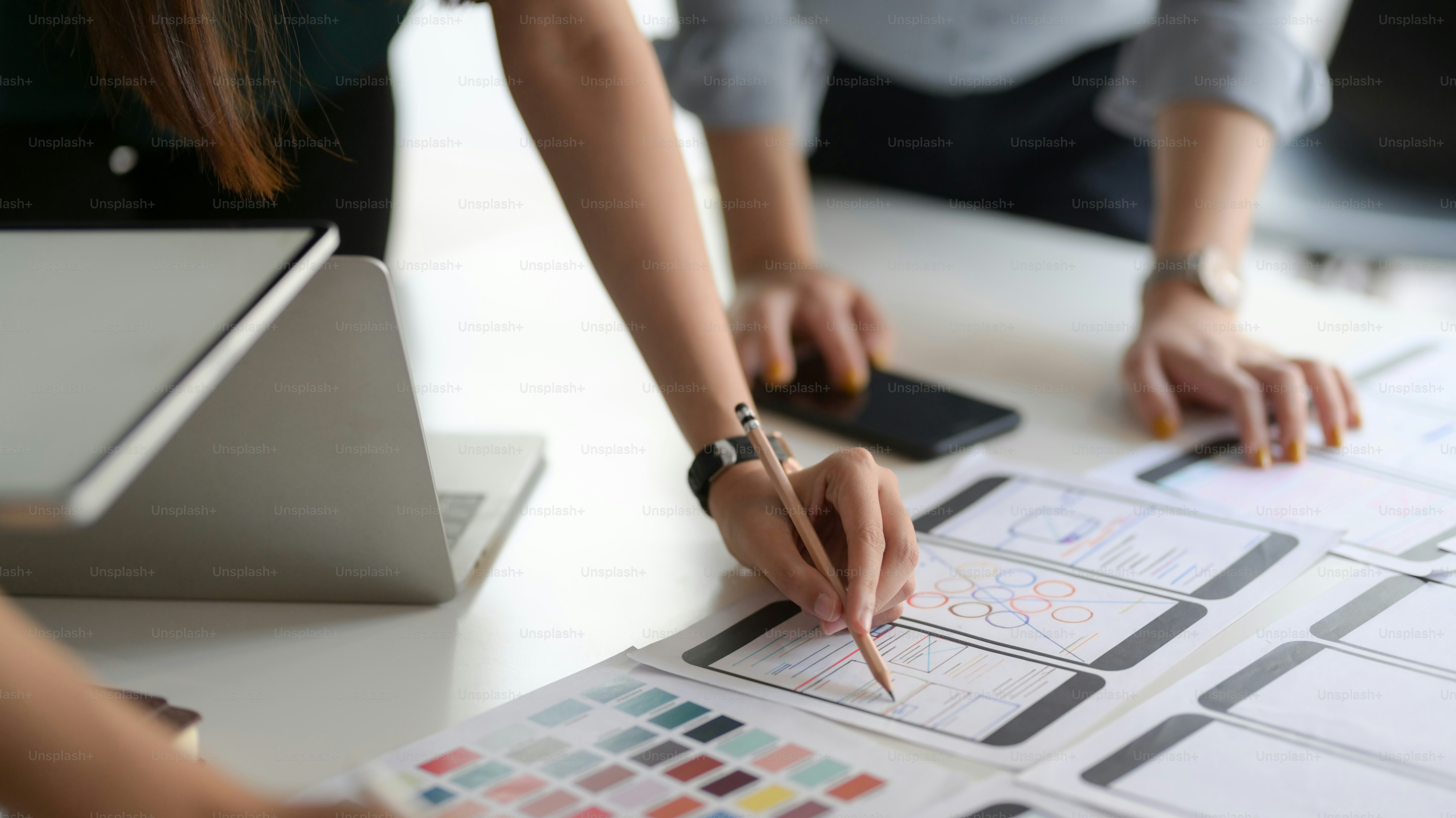 Close-up view of young professional UI graphic designer team choosing the colour for their smartphone template