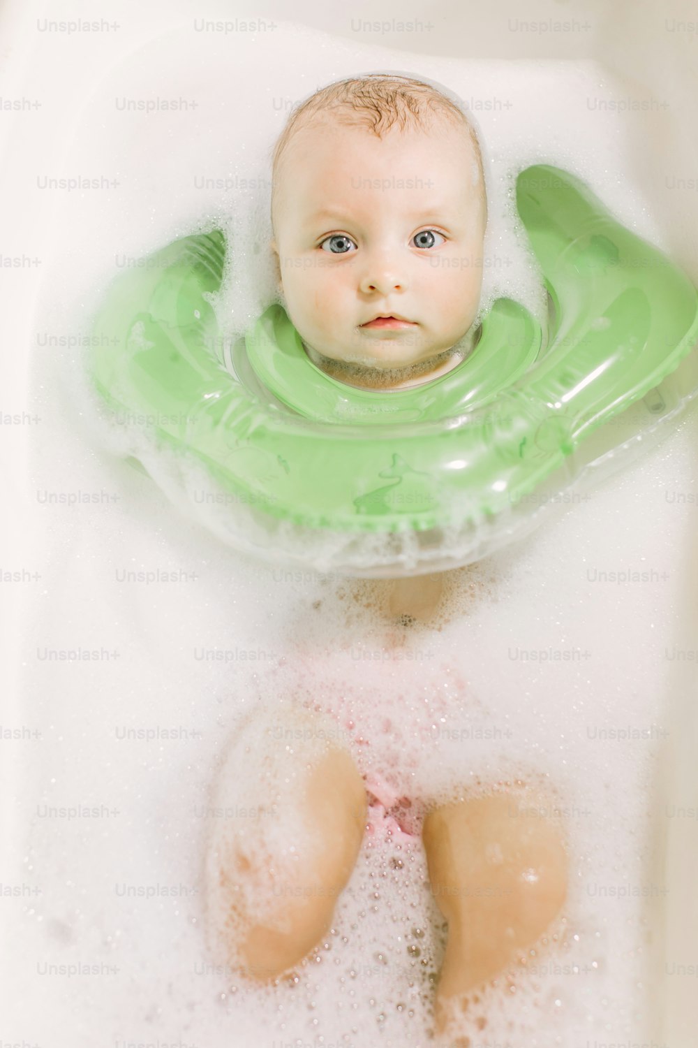 Baby swimming with green neck swim ring