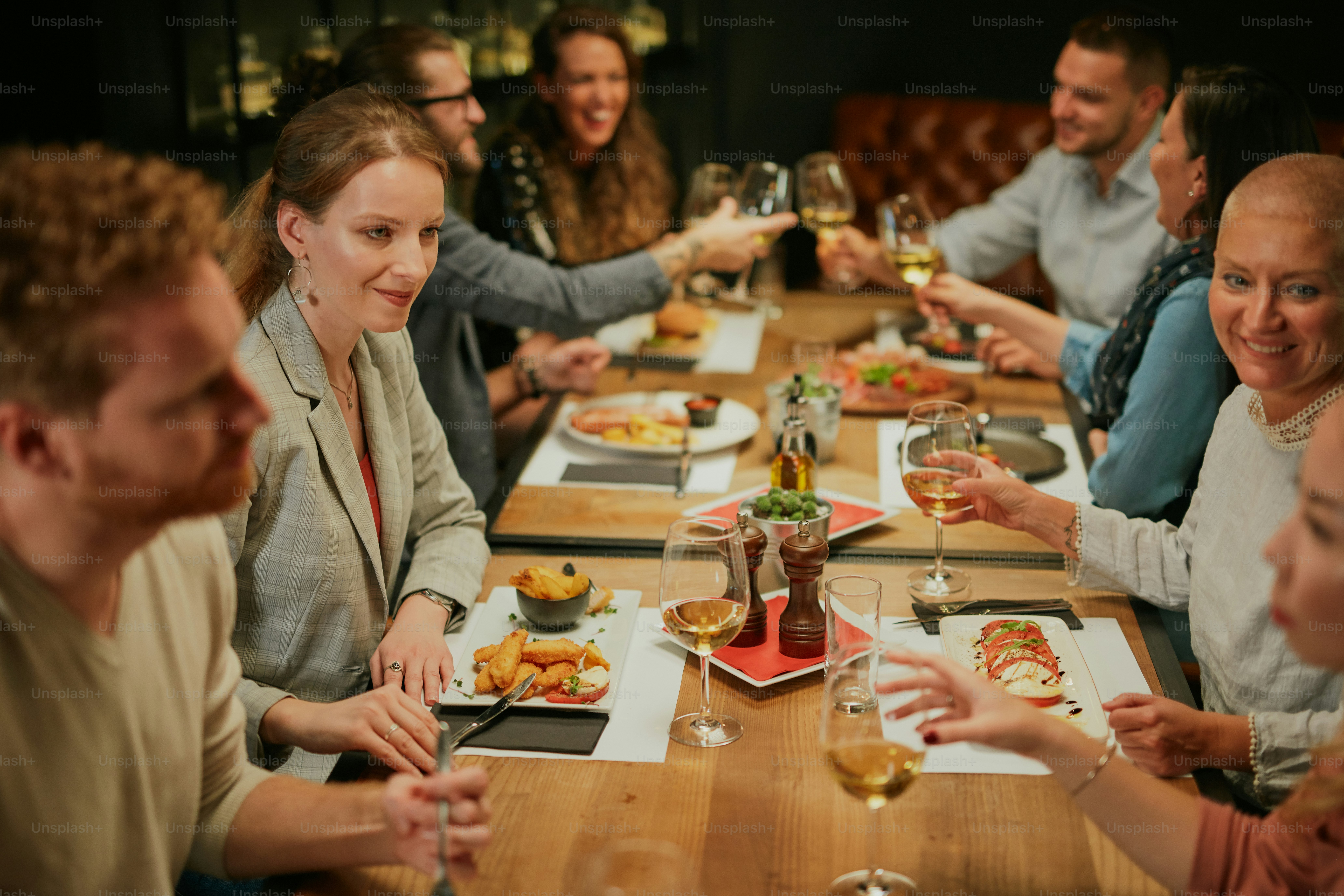 Group of friends sitting in retaurant and eating dinner.