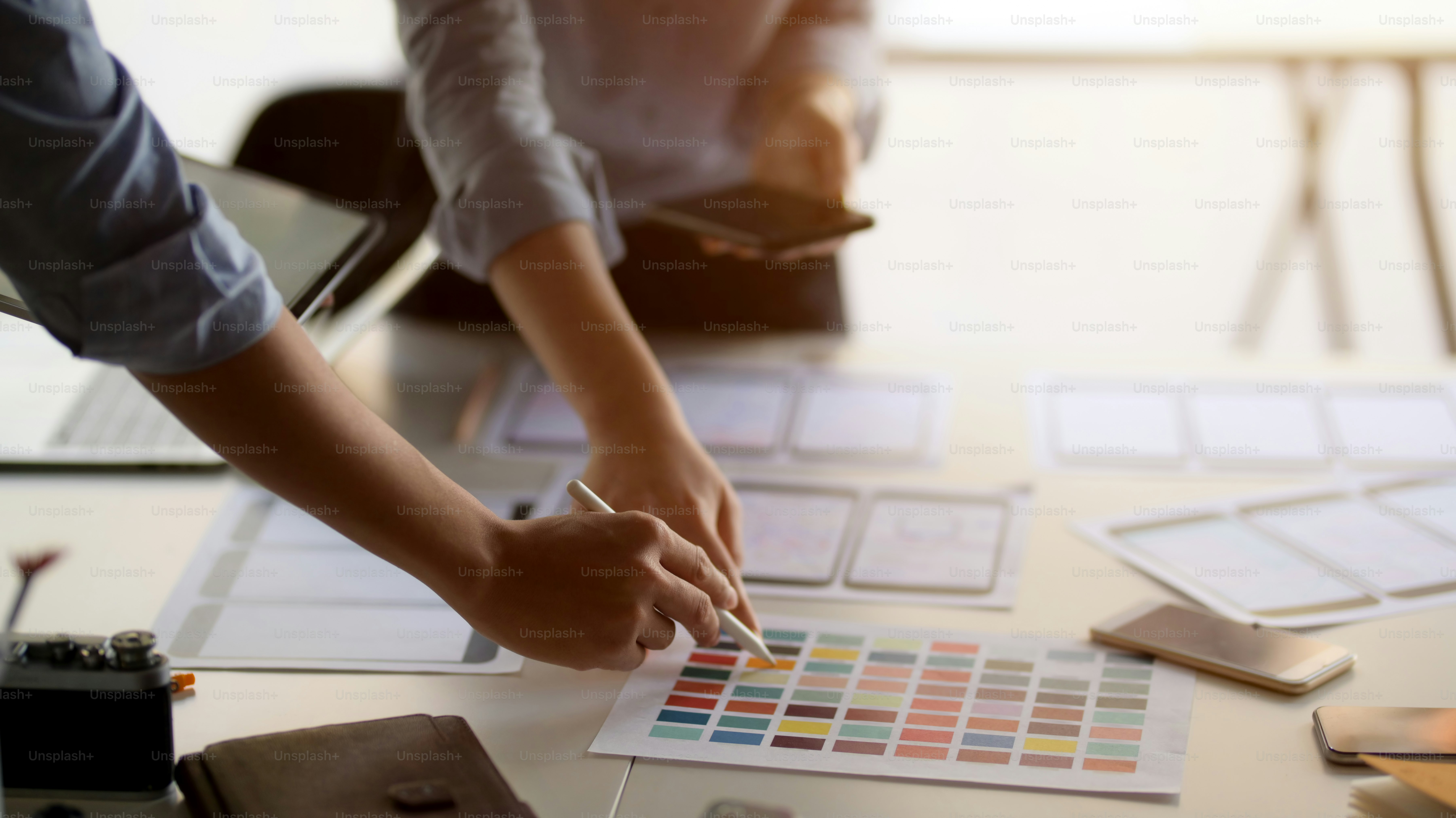 Close-up view of young professional UI graphic designer team choosing the colour for their smartphone template