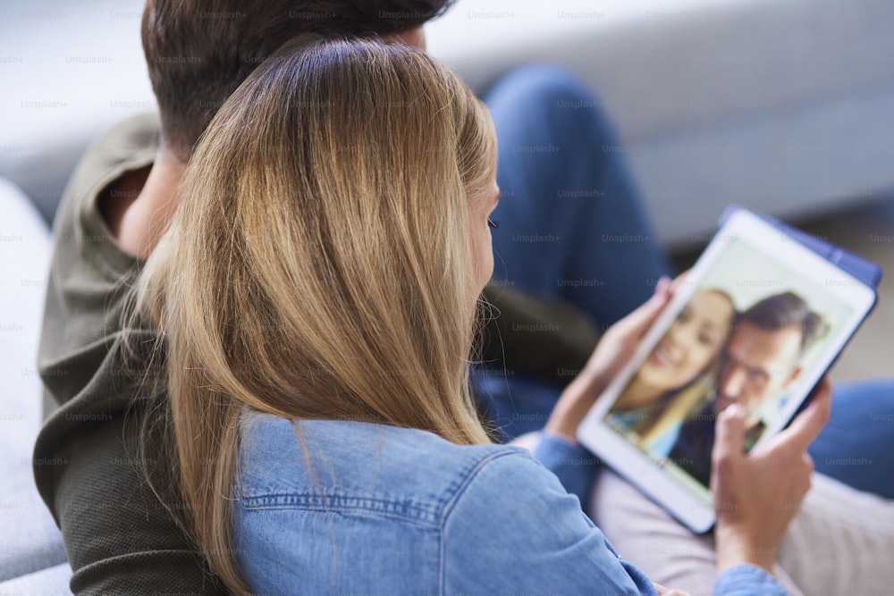 Close up of couple embracing and using a tablet