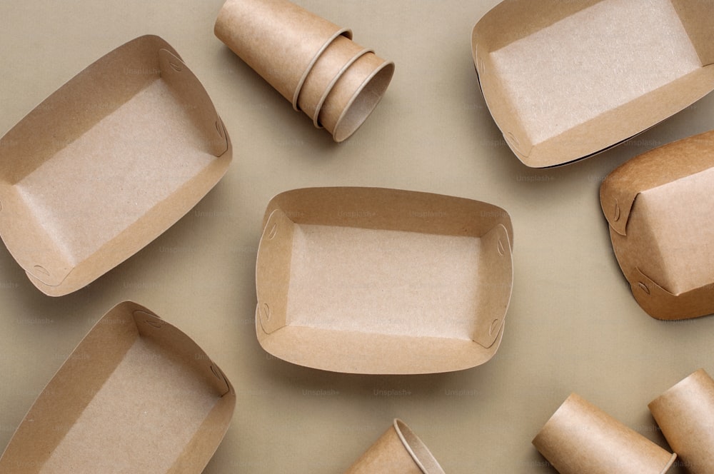 Disposable eco friendly food packaging. Brown kraft paper food containers on beige background. Top view, flat lay. "n