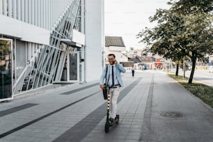 Junger moderner Mann, der Elektroroller auf der Straße der Stadt benutzt und fährt. Modernes und ökologisches Verkehrskonzept.
