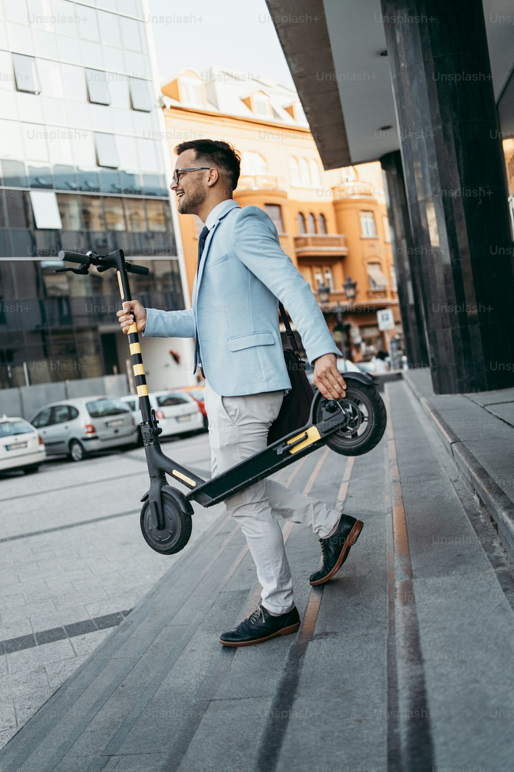 Young modern man using and driving electric scooter on city street. Modern and ecological transportation concept.